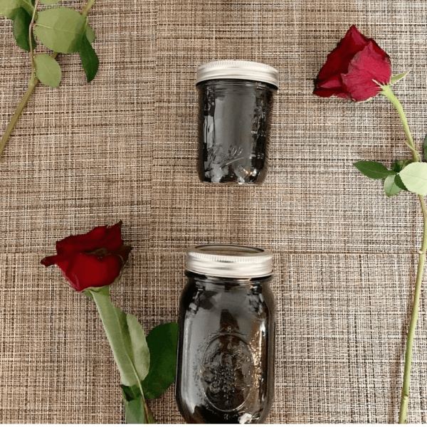 Mason jars on cloth filled with elderberry syrup