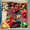 Medium box filled with assortment of meats, cheeses, fruit, and veggies