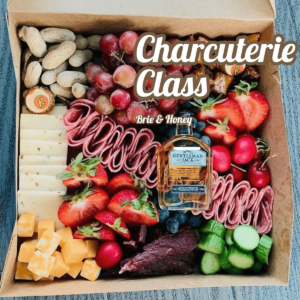 Charcuterie box with assorted meats, cheeses, and veggies.